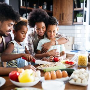 Happy family in the kitchen having fun and cooking together. Healthy food at home.